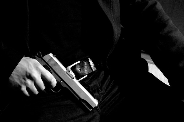 Photo midsection of man holding handgun