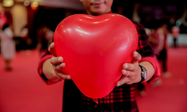 Foto sezione centrale di un uomo che tiene un palloncino a forma di cuore