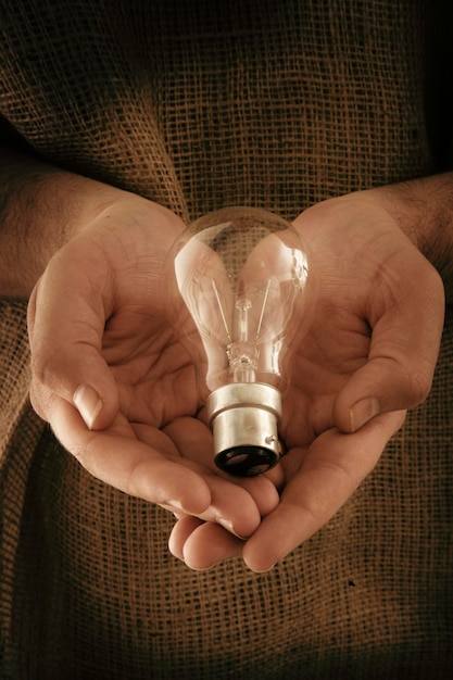 Foto sezione centrale di un uomo che tiene una lampadina