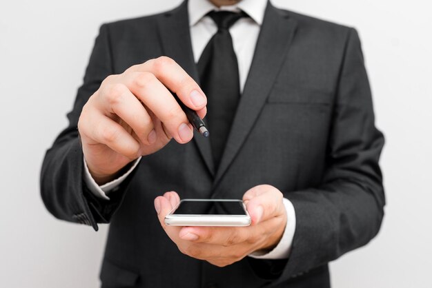 Foto sezione centrale di un uomo che tiene in mano un telefono cellulare sullo sfondo bianco