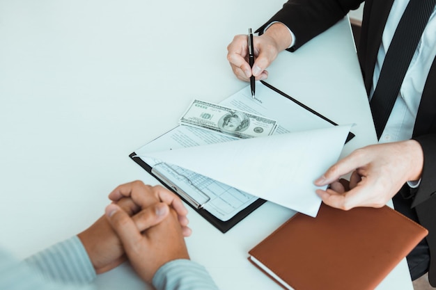 Midsection of man holding paper with text on table