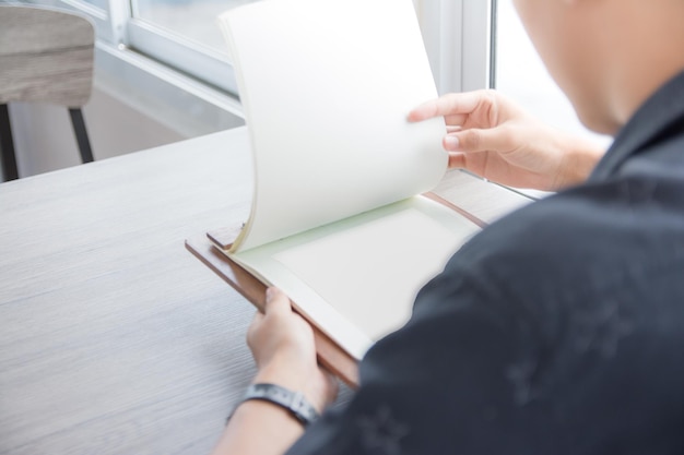 Midsection of man holding papers at table