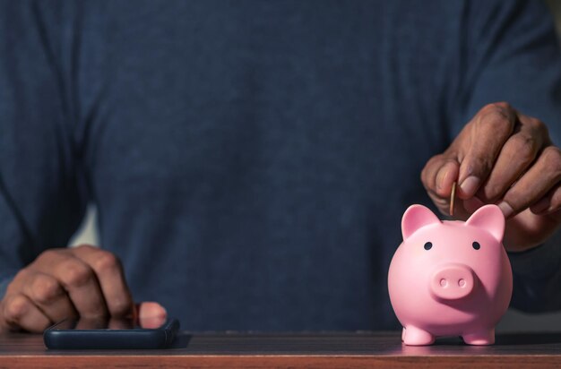 Photo midsection of man holding piggy bank