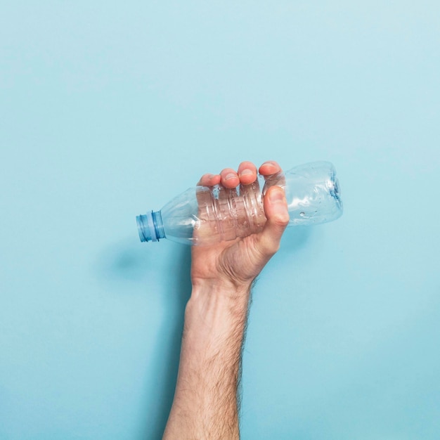 Midsection of man holding plastic against white background