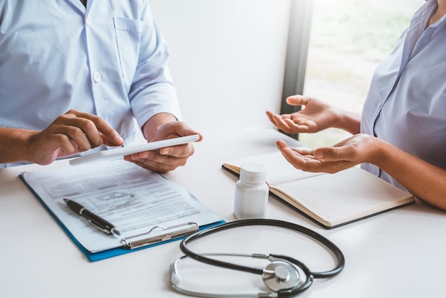 Midsection of man holding smart phone on table