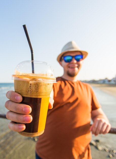 Midsection of man holding sunglasses against sky