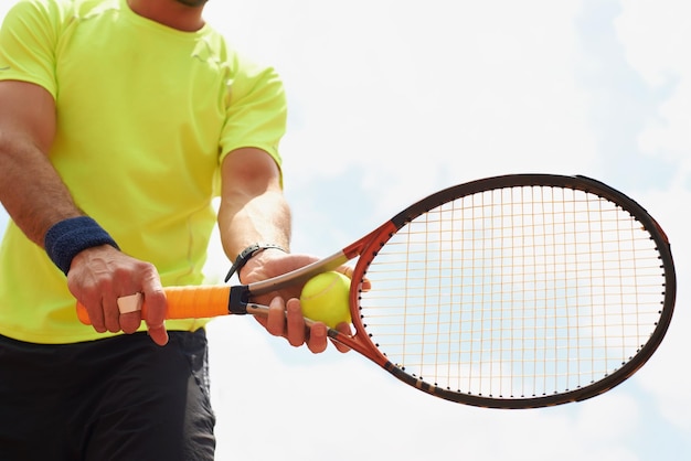 Foto sezione centrale di un uomo che tiene in mano il tennis