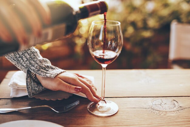 Midsection of man holding wineglass on table