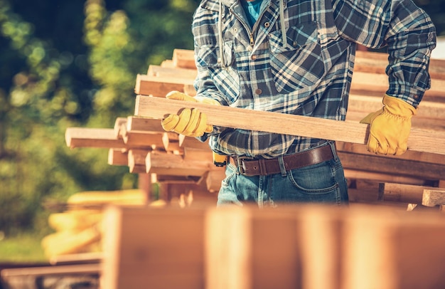 Photo midsection of man holding wood at construction site