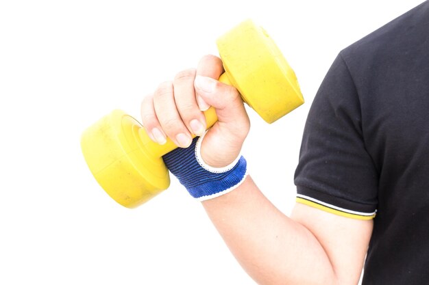 Midsection of man holding yellow dumbbell over white background