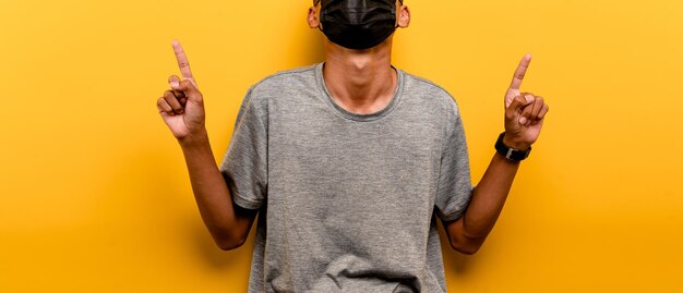 Midsection of man holding yellow umbrella against orange background