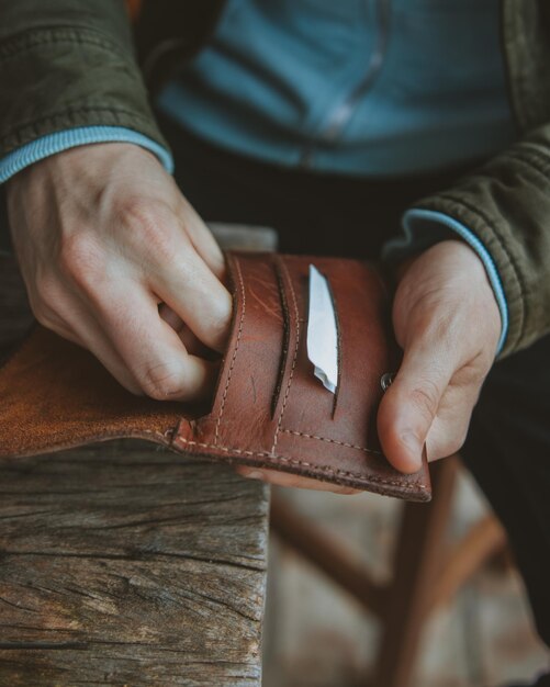 Photo midsection of man keeping cigarettes in leather wallet