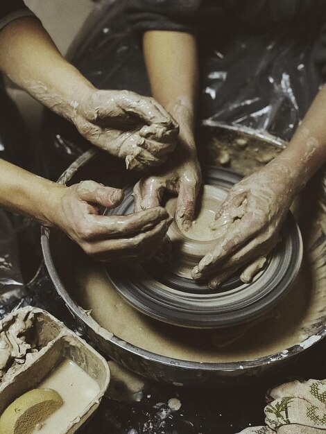 Photo midsection of man making pot with coworker