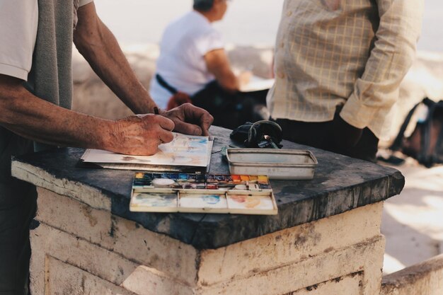 Photo midsection of man painting while standing at table