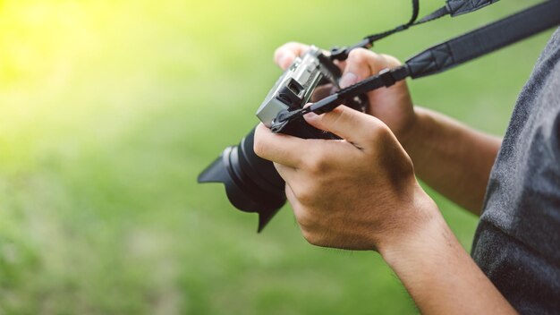 Midsection of man photographing with camera while standing on field