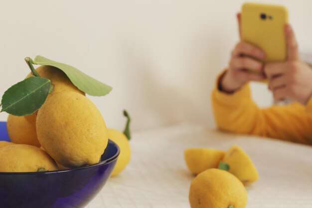 Midsection of man photographing with mobile phone on table