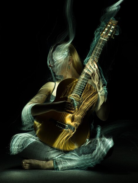 Foto sezione centrale di un uomo che suona la chitarra su uno sfondo nero