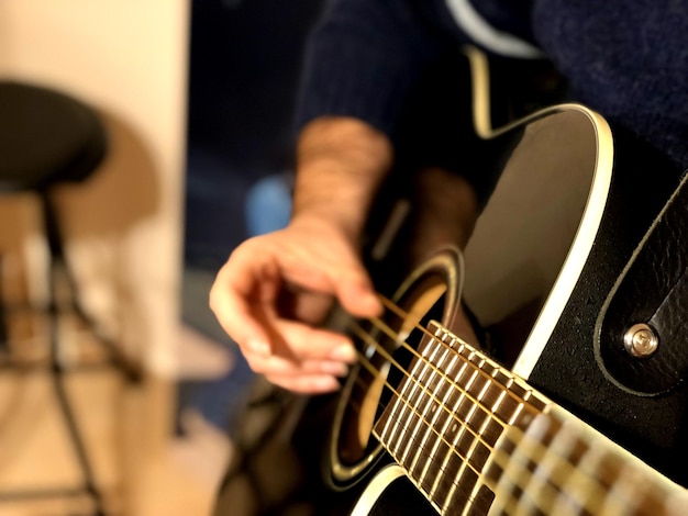 Foto sezione centrale di un uomo che suona la chitarra