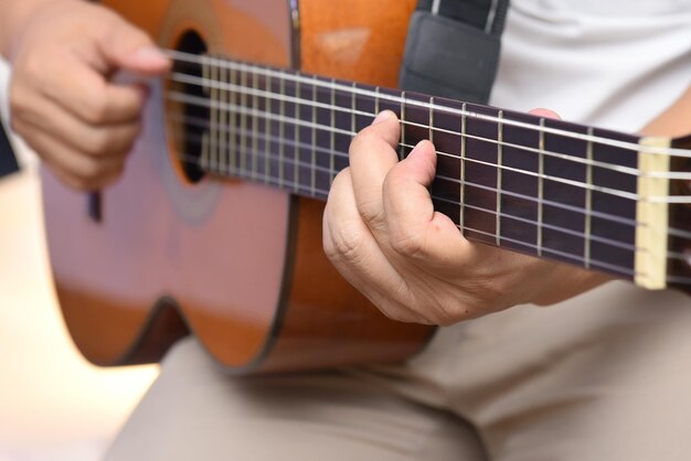 Midsection of man playing guitar