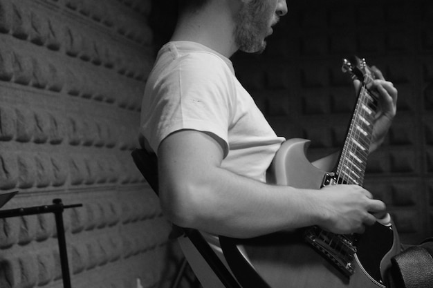 Foto sezione centrale di un uomo che suona la chitarra