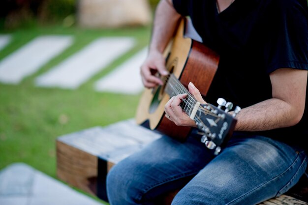 Midsection of man playing guitar