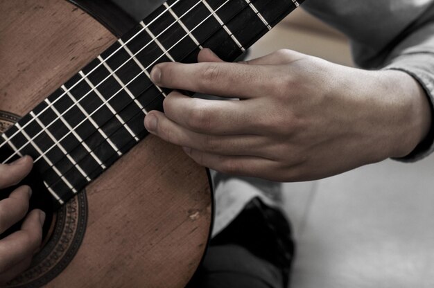 Midsection of man playing guitar