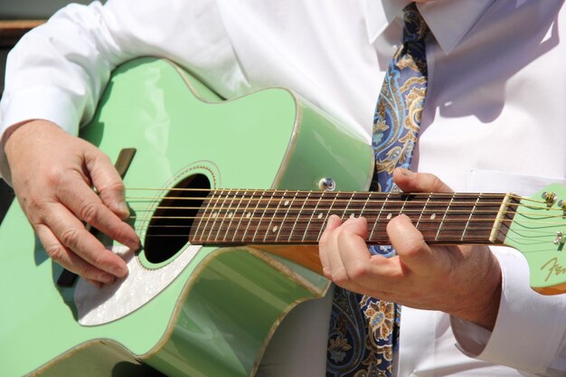 Foto sezione centrale di un uomo che suona la chitarra