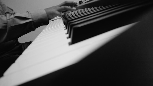 Foto sezione centrale di un uomo che suona il pianoforte a casa