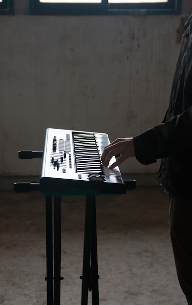 Foto sezione centrale di un uomo che suona il pianoforte in piedi sul pavimento