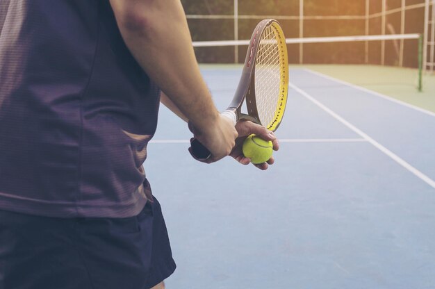 Foto sezione centrale di un uomo che gioca a tennis in campo