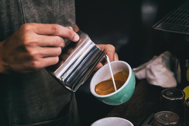 Photo midsection of man pouring cream in coffee