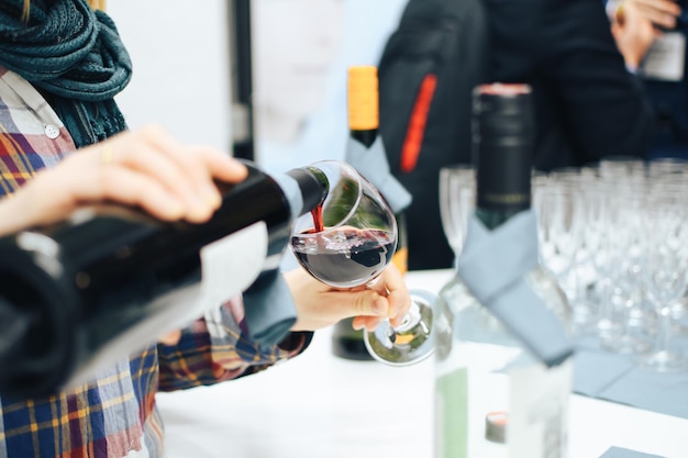 Photo midsection of man pouring wine in glass on table