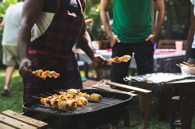 Photo midsection of man preparing food on barbecue grill