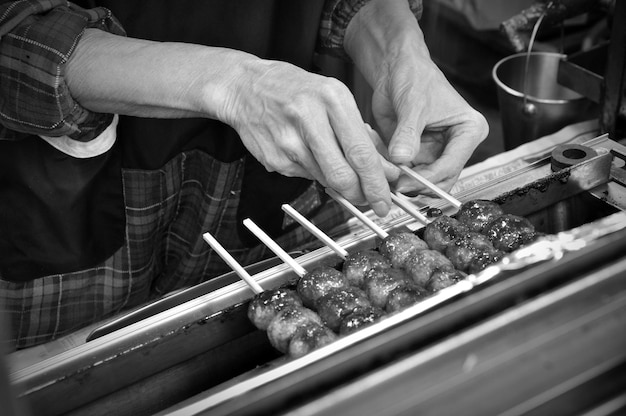 Midsection of man preparing food on barbecue grill