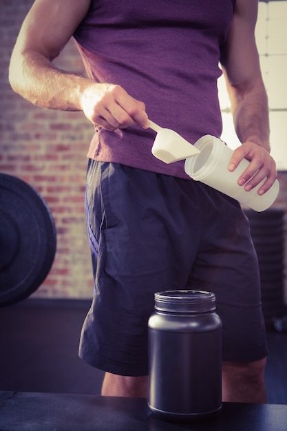 Photo midsection of man putting supplement into bottle