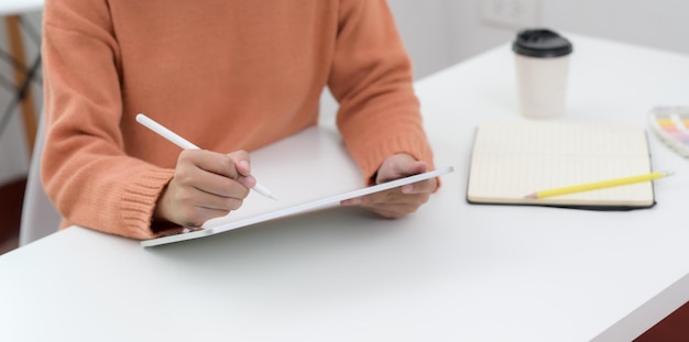 Midsection of man reading book on table