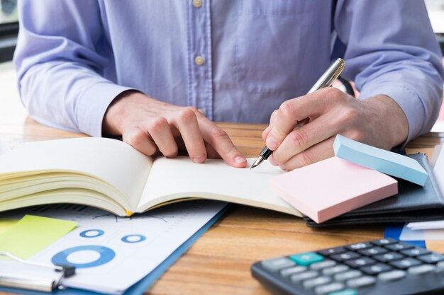 Midsection of man reading book on table