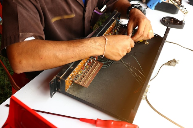 Photo midsection of man repairing computer part in workshop