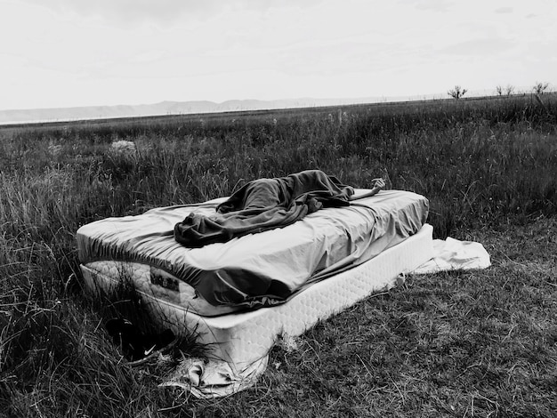 Midsection of man sleeping on field against sky