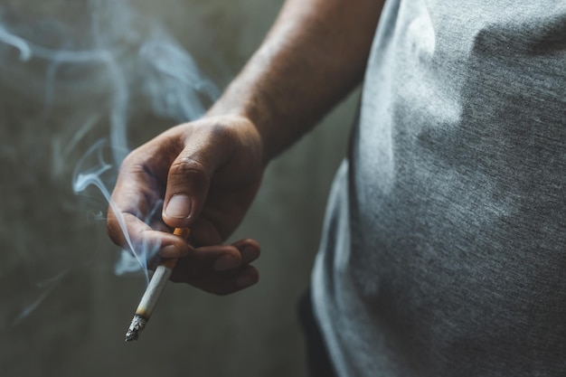 midsection of man smoking cigarette