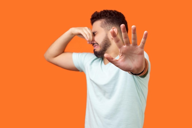 Midsection of man standing against orange background