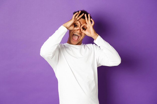 Midsection of man standing against purple background