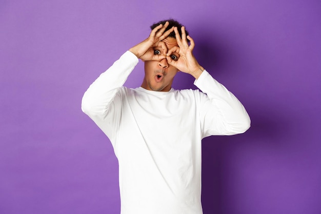 Midsection of man standing against purple wall