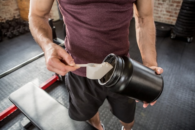 Midsection of man taking supplement from tin