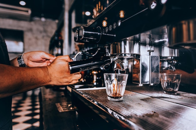 Foto sezione centrale di un uomo che usa la macchina del caffè