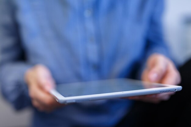 Photo midsection of man using digital tablet at home