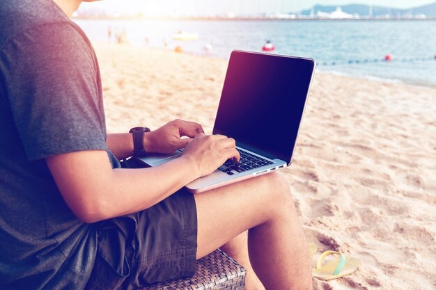 Photo midsection of man using laptop at beach