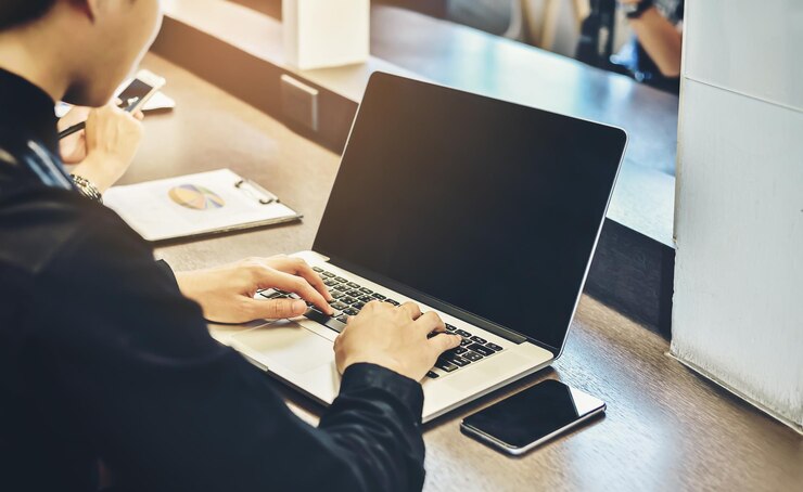 Photo テーブルでラップトップを使用している男性のミッドセクション