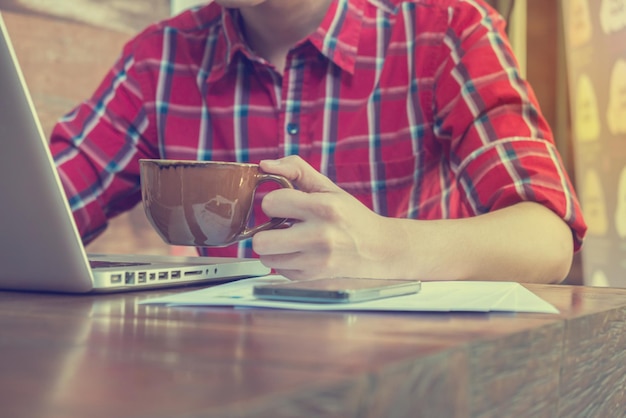 Photo midsection of man using laptop at table