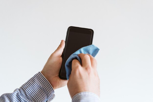 midsection of man using mobile phone against white background